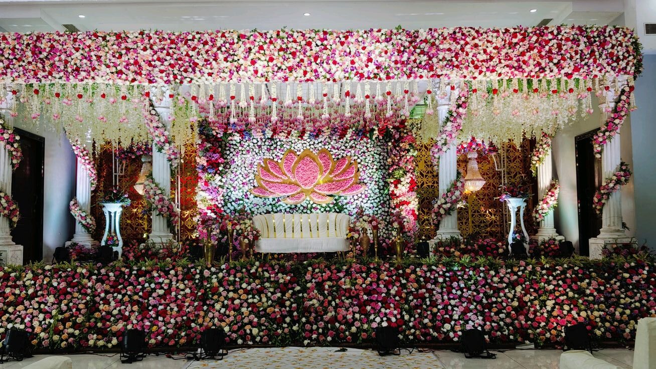 Elegant floral wedding stage decoration with lotus backdrop designed for a grand wedding celebration in Hyderabad.