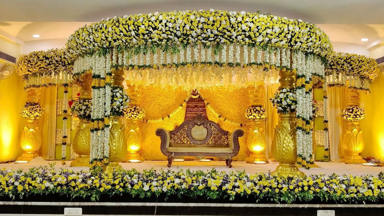 Luxury reception stage decoration with yellow and white floral canopy in Hyderabad