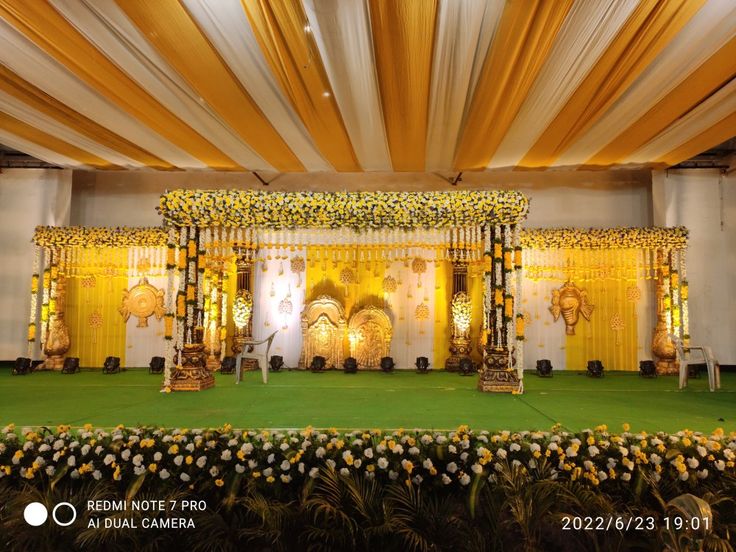 Elegant haldi stage decoration with yellow and white floral canopy and traditional backdrop setup in Hyderabad.