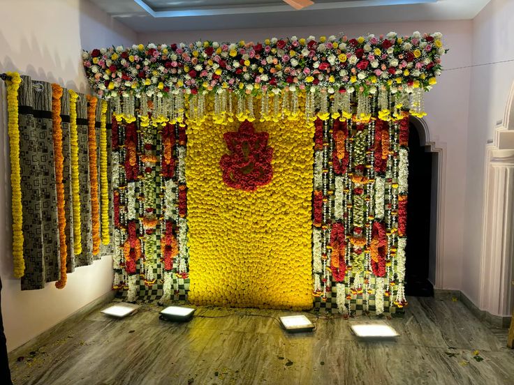 Beautiful Ganesh floral backdrop decoration with yellow flower wall and hanging garlands for traditional events in Hyderabad.
