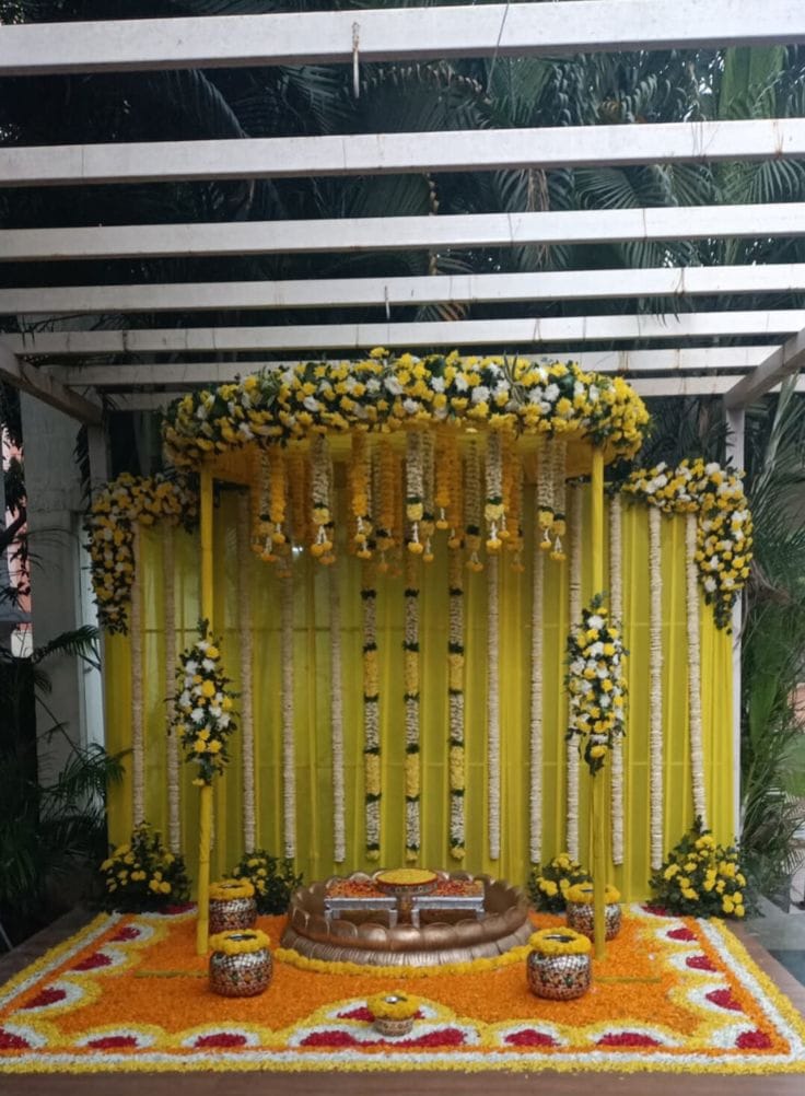 Beautiful haldi ceremony decoration setup with floral canopy, yellow backdrop, and traditional seating arrangement in Hyderabad.