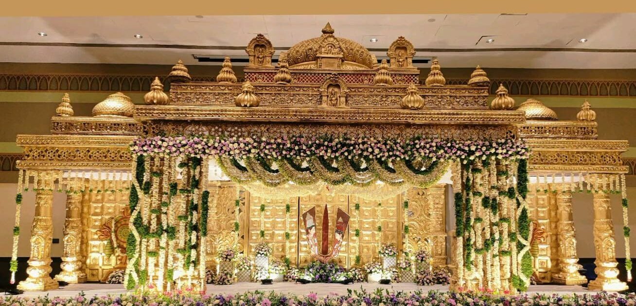 Elegant temple-style South Indian wedding mandap decoration with floral garlands and royal golden backdrop in Hyderabad.