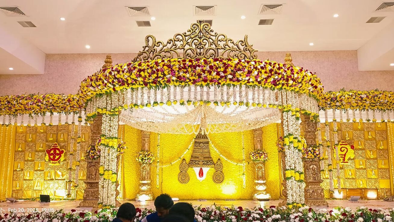 Grand traditional wedding mandap decoration with floral canopy, carved pillars, and yellow floral backdrop in Hyderabad.