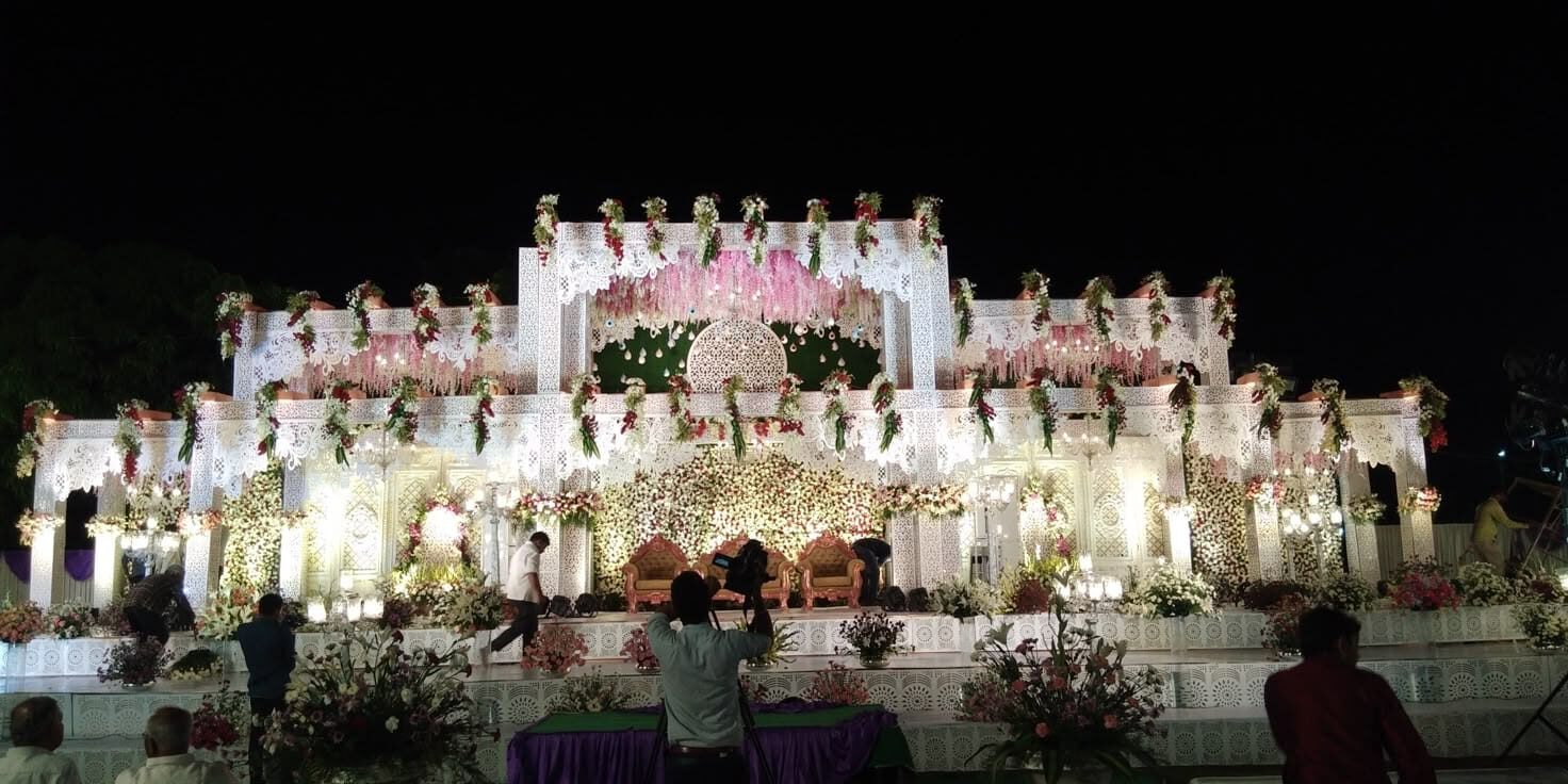 Grand luxury wedding reception stage with white palace-style decor and floral arrangements for premium events in Hyderabad.